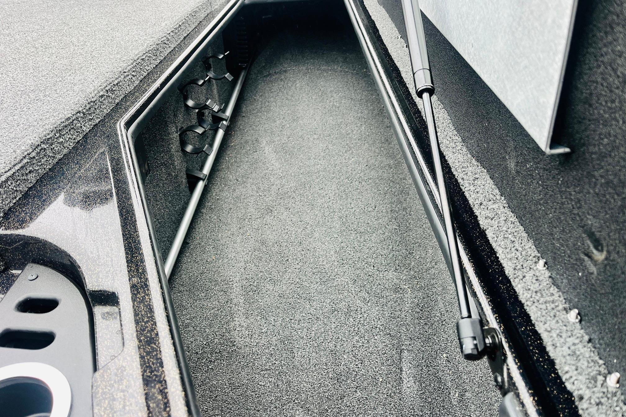 Slide: The Image of Interior storage compartment of 2021 Nitro Z19 Pro boat, featuring rod holders and carpeted finish. - 24