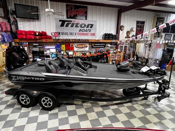 Slide: The Image of 2023 Nitro Z19 Pro bass boat in showroom with fishing gear. - 1