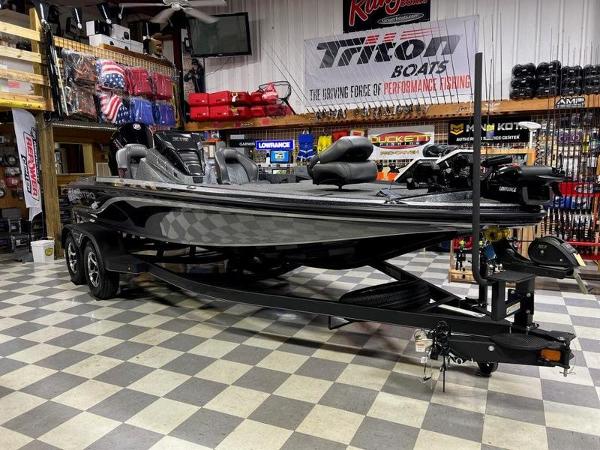 Slide: The Image of 2023 Nitro Z19 Pro bass boat displayed in a showroom with fishing gear. - 2
