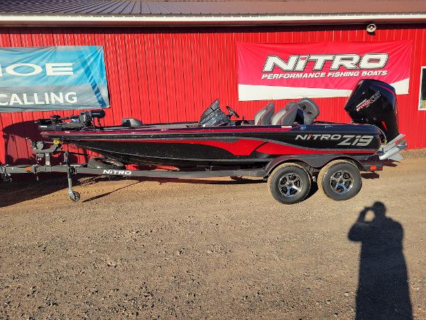 Slide: The Image of 2024 Nitro Z19 Pro fishing boat in black and red, parked on a trailer. - 0