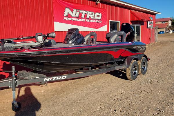 Slide: The Image of 2024 Nitro Z19 Pro fishing boat parked outside a red building. - 1