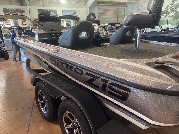 Slide: The Image of 2024 Nitro Z19 Pro boat in showroom, side view with seating and trailer. - 2