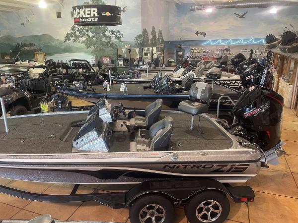 Slide: The Image of 2024 Nitro Z19 Pro fishing boats displayed in a showroom with scenic mural background. - 3