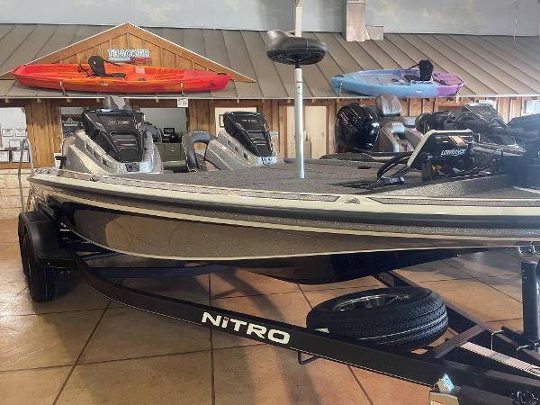 Slide: The Image of 2024 Nitro Z19 Pro fishing boat displayed indoors with kayaks in the background. - 6
