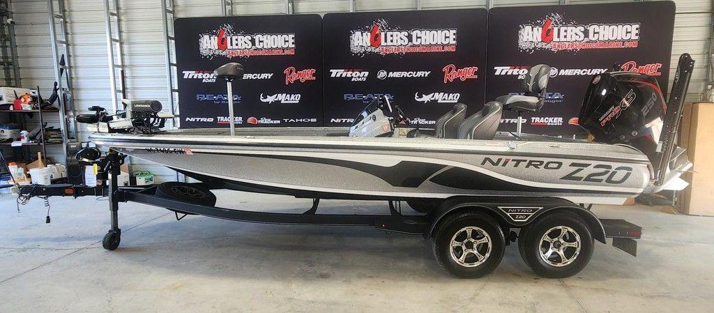 Slide: The Image of 2022 Nitro Z20 boat in showroom, featuring sleek design and dual-axle trailer. - 0