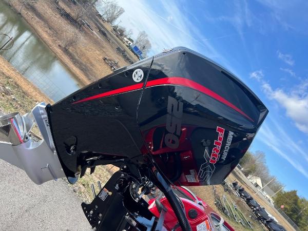 Slide: The Image of 2023 Nitro Z20 Pro boat engine with red and black design near a lake. - 8