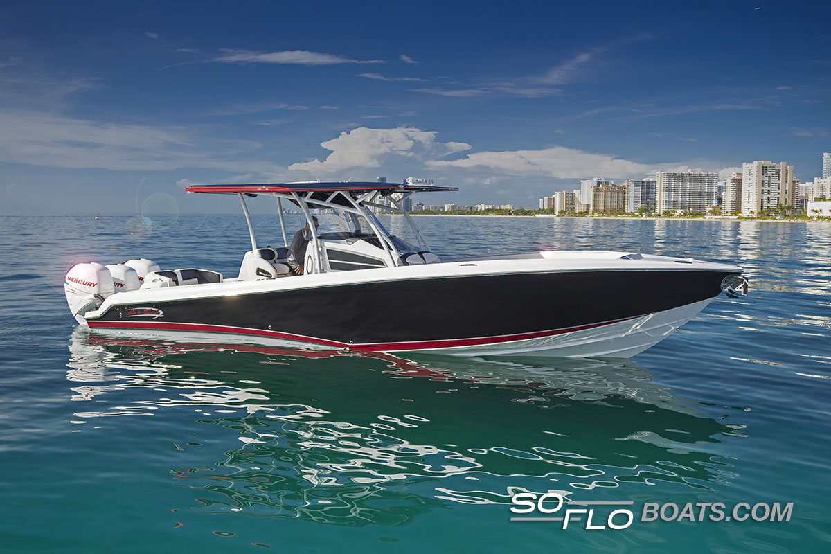 Slide: The Image of 2024 Nor-Tech 340 Sport Center Console boat on calm water with city skyline. - 0