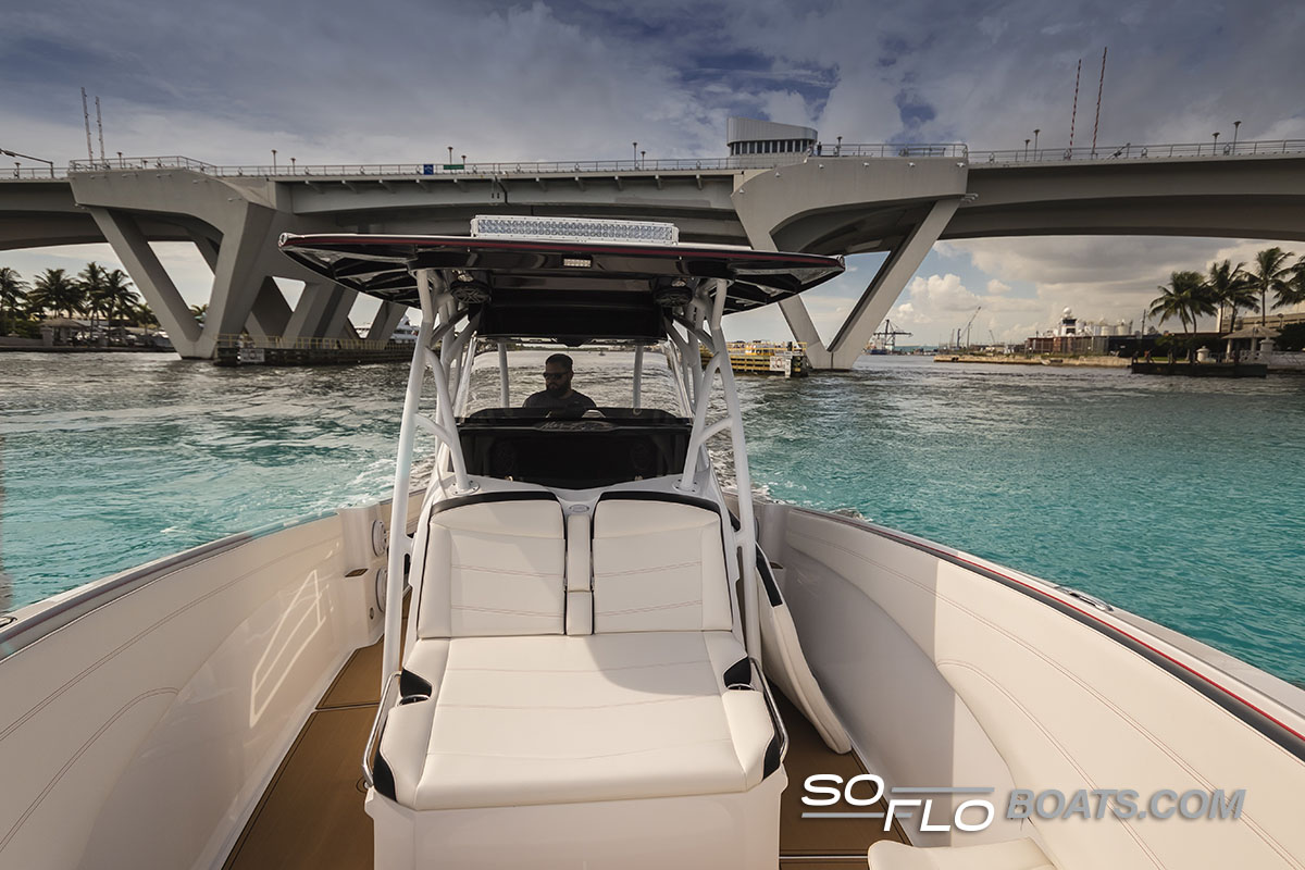 Slide: The Image of 2024 Nor-Tech 340 Sport Center Console boat cruising under a bridge. - 5