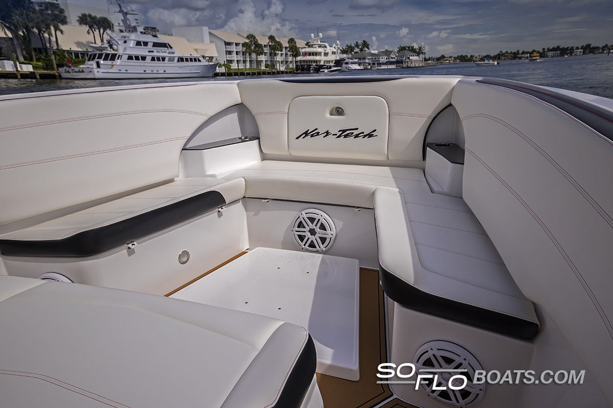 Slide: The Image of 2024 Nor-Tech 340 Sport Center Console boat interior with white seating and waterfront view. - 7