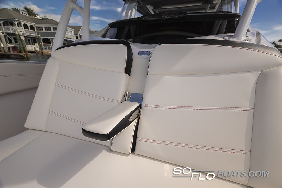 Slide: The Image of 2024 Nor-Tech 340 Sport Center Console boat seating with armrest, waterfront background. - 8
