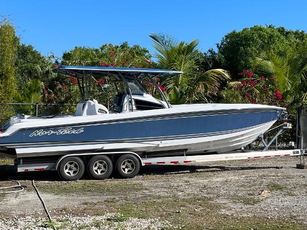 Slide: The Image of 2023 Nor-Tech 340 Sport boat on a trailer, surrounded by tropical plants. - 4