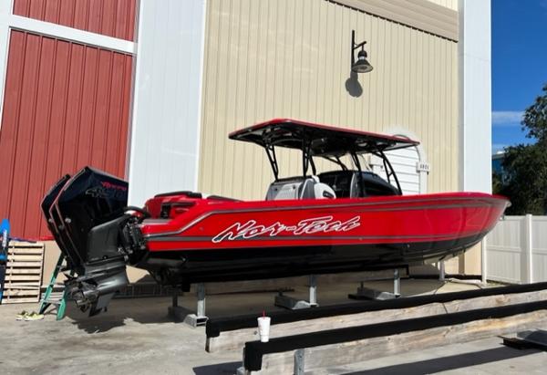 Slide: The Image of 2022 Nor-Tech 390 Sport Center Console boat in red, docked at a marina. - 1