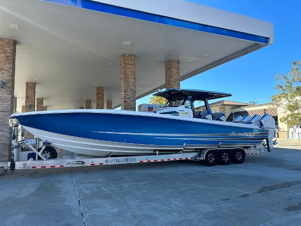 Slide: The Image of 2024 Nor-Tech 400 Supersport boat on a trailer at a gas station. - 1