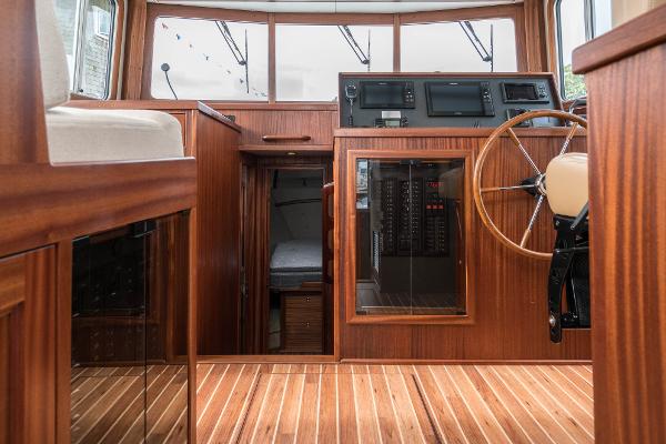 Slide: The Image of 2025 Nordic Tug 40 interior with wooden finish and modern navigation equipment. - 10