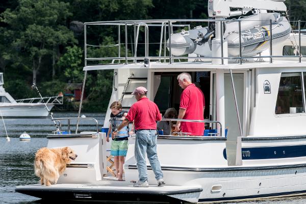 Slide: The Image of Family enjoying time on a 2025 Nordic Tug 40 boat with their dog. - 13