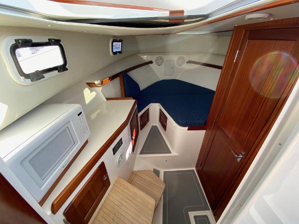 Slide: The Image of 2021 NorthCoast 315 HT cabin interior with wood finishes and blue bedding. - 13