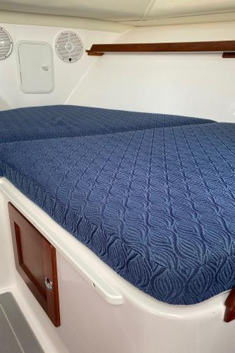 Slide: The Image of 2021 NorthCoast 315 HT cabin interior with blue mattress and wooden accents. - 15