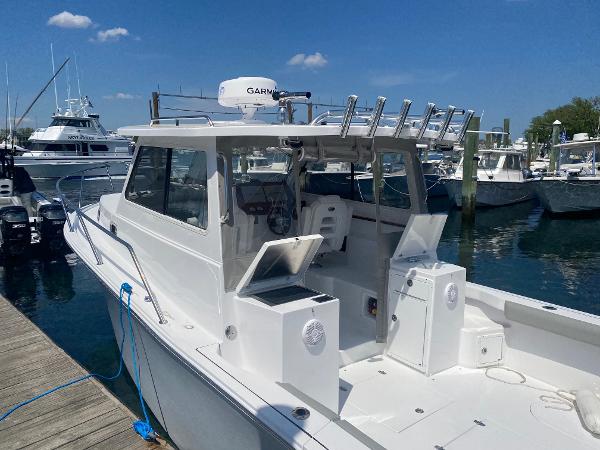 Slide: The Image of 2021 NorthCoast 315 HT boat docked at a marina on a sunny day. - 4