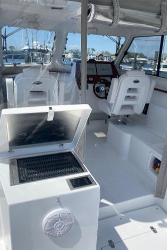 Slide: The Image of 2021 NorthCoast 315 HT boat interior with helm and seating. - 5