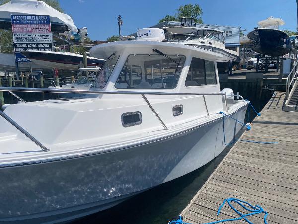 Slide: The Image of 2021 NorthCoast 315 HT boat docked at a marina with clear blue skies. - 7