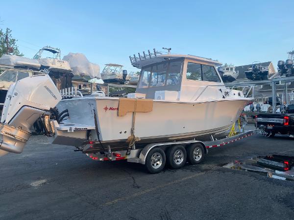 Slide: The Image of 2021 NorthCoast 315 HT boat on a trailer in a marina. - 8