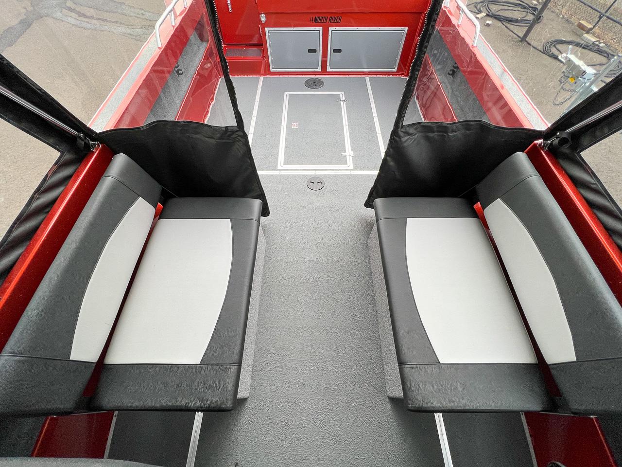 Slide: The Image of 2024 North River 23 SeaHawk interior seating area with black and white cushioned benches. - 13