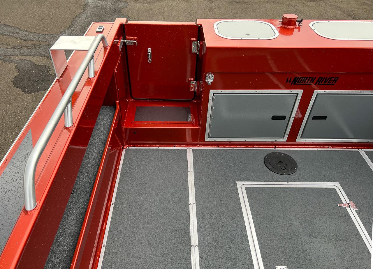 Slide: The Image of 2024 North River 23 SeaHawk boat interior, featuring red and gray design with storage compartments. - 18