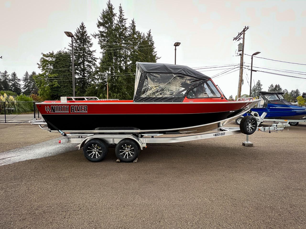 Slide: The Image of 2024 North River 23 SeaHawk boat on a trailer, red and black exterior. - 2