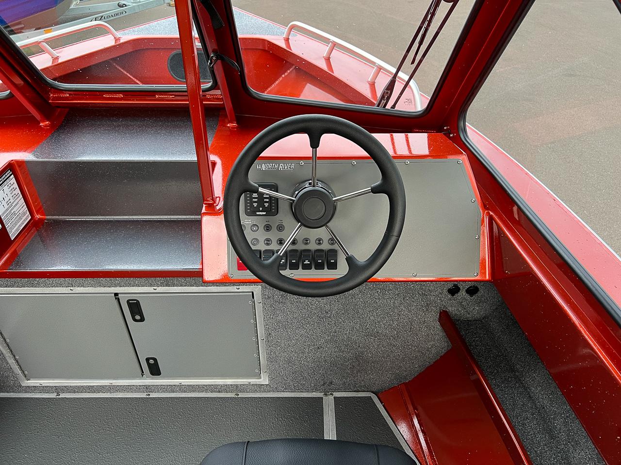 Slide: The Image of 2024 North River 23 SeaHawk boat dashboard with steering wheel and control panel. - 9