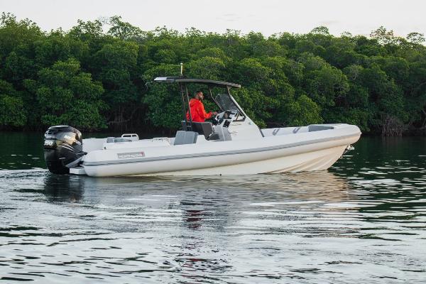 Slide: The Image of 2024 Northstar Orion 8 boat cruising on calm water near lush greenery. - 1