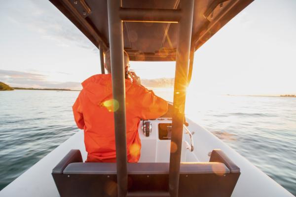 Slide: The Image of Person in orange jacket steering 2024 Northstar Orion 8 boat at sunset. - 15