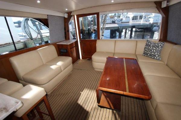 Slide: The Image of Luxurious interior of 1990 Ocean Yachts 48 Super Sport with beige seating and wooden table. - 10