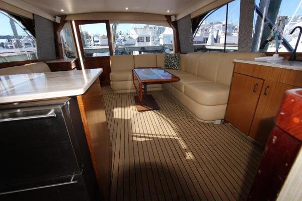 Slide: The Image of Interior of a 1990 Ocean Yachts 48 Super Sport with beige seating and wooden accents. - 11