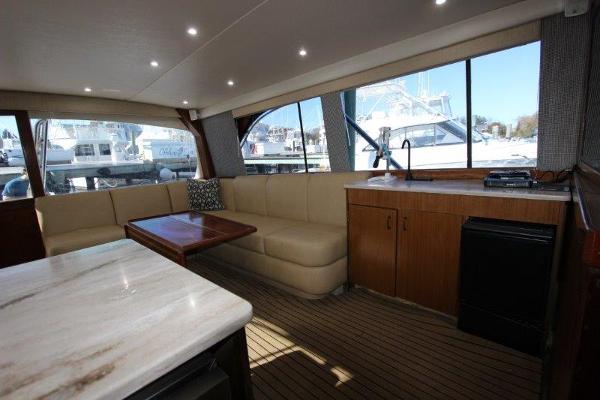 Slide: The Image of Interior of 1990 Ocean Yachts 48 Super Sport with beige seating and wooden table. - 12