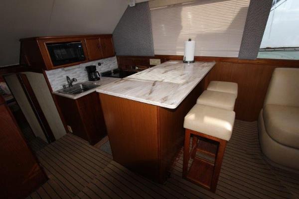 Slide: The Image of 1990 Ocean Yachts 48 Super Sport kitchen with marble countertop and wooden cabinetry. - 13