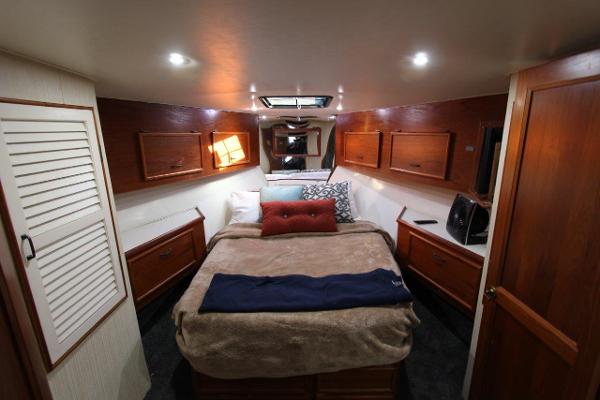 Slide: The Image of 1990 Ocean Yachts 48 Super Sport bedroom with cozy bed and wooden cabinetry. - 19