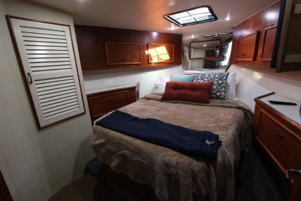 Slide: The Image of Cozy bedroom in a 1990 Ocean Yachts 48 Super Sport with wooden cabinets and skylight. - 21