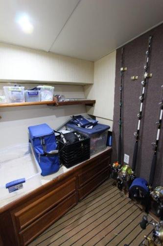 Slide: The Image of 1990 Ocean Yachts 48 Super Sport fishing gear storage room with rods and tackle boxes. - 25