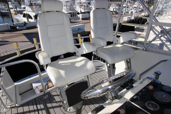 Slide: The Image of 1990 Ocean Yachts 48 Super Sport helm with white captain chairs and steering wheel. - 28