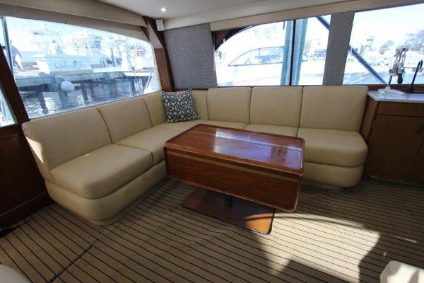 Slide: The Image of Luxurious interior of 1990 Ocean Yachts 48 Super Sport with beige seating and wooden table. - 8