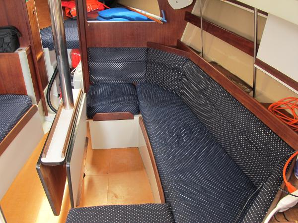 Slide: The Image of Interior of 1987 O'Day 322 sailboat with blue cushioned seating and wooden accents. - 26
