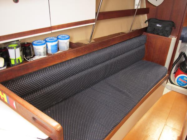 Slide: The Image of 1987 O'Day 322 sailboat interior with cushioned seating and storage shelves. - 27