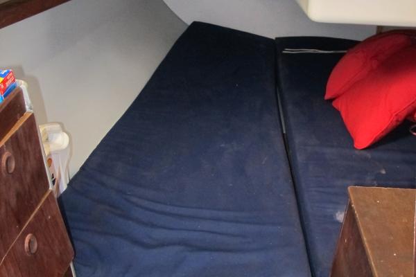 Slide: The Image of Interior cabin bed of 1987 O'Day 322 sailboat with blue mattress and red pillows. - 35