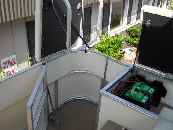 Slide: The Image of 2004 Odyssey Millennium 2502M boat battery compartment with open storage hatches. - 8