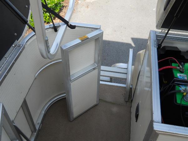 Slide: The Image of 2004 Odyssey Millennium 2502M boat interior with open battery compartment and entry gate. - 9