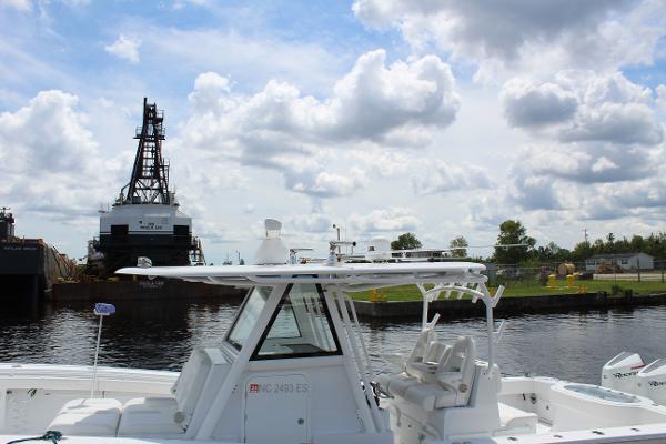 Slide: The Image of 2021 Onslow Bay 41 Tournament Edition boat docked near industrial area under cloudy sky. - 34