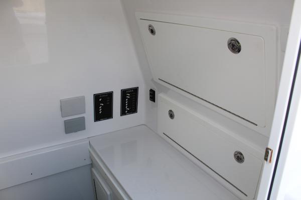Slide: The Image of Interior storage compartments and control panels of a 2021 Onslow Bay 41 Tournament Edition boat. - 36