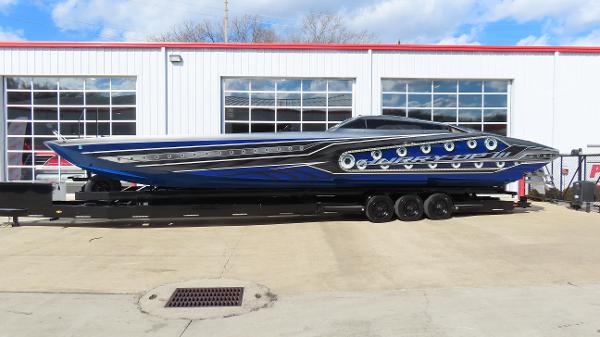 Slide: The Image of 2020 Outerlimits 46SC powerboat on a trailer outside a garage. - 1