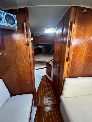 Slide: The Image of Interior of 1986 Pacific Seacraft 37 sailboat with wooden cabinetry and white seating. - 14