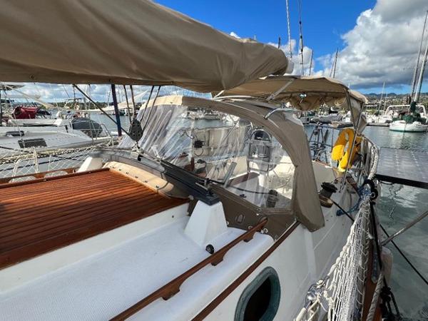 Slide: The Image of 1986 Pacific Seacraft 37 sailboat docked at marina, featuring tan canvas covers. - 4